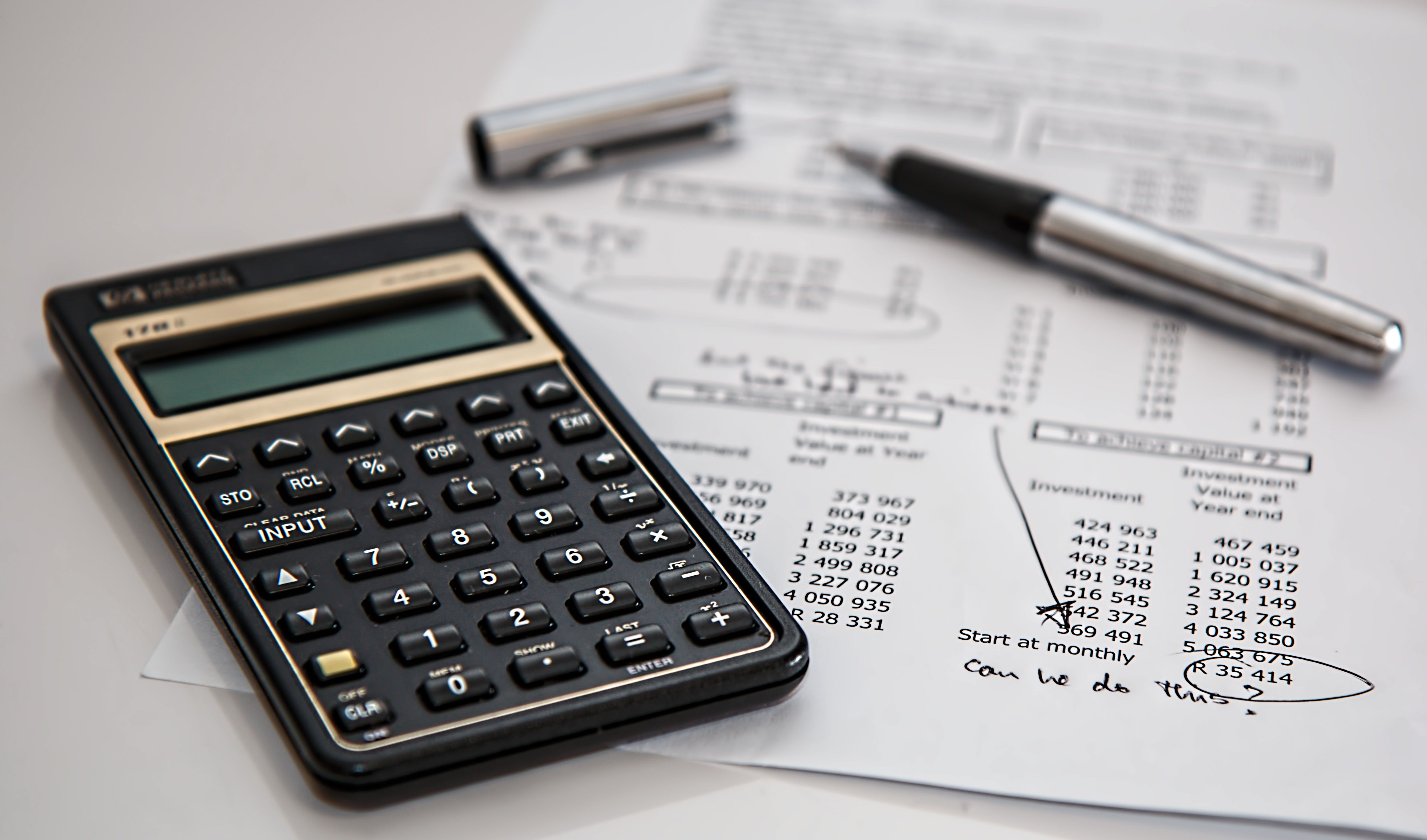 Close-up of financial documents with calculator and pen for project budgeting