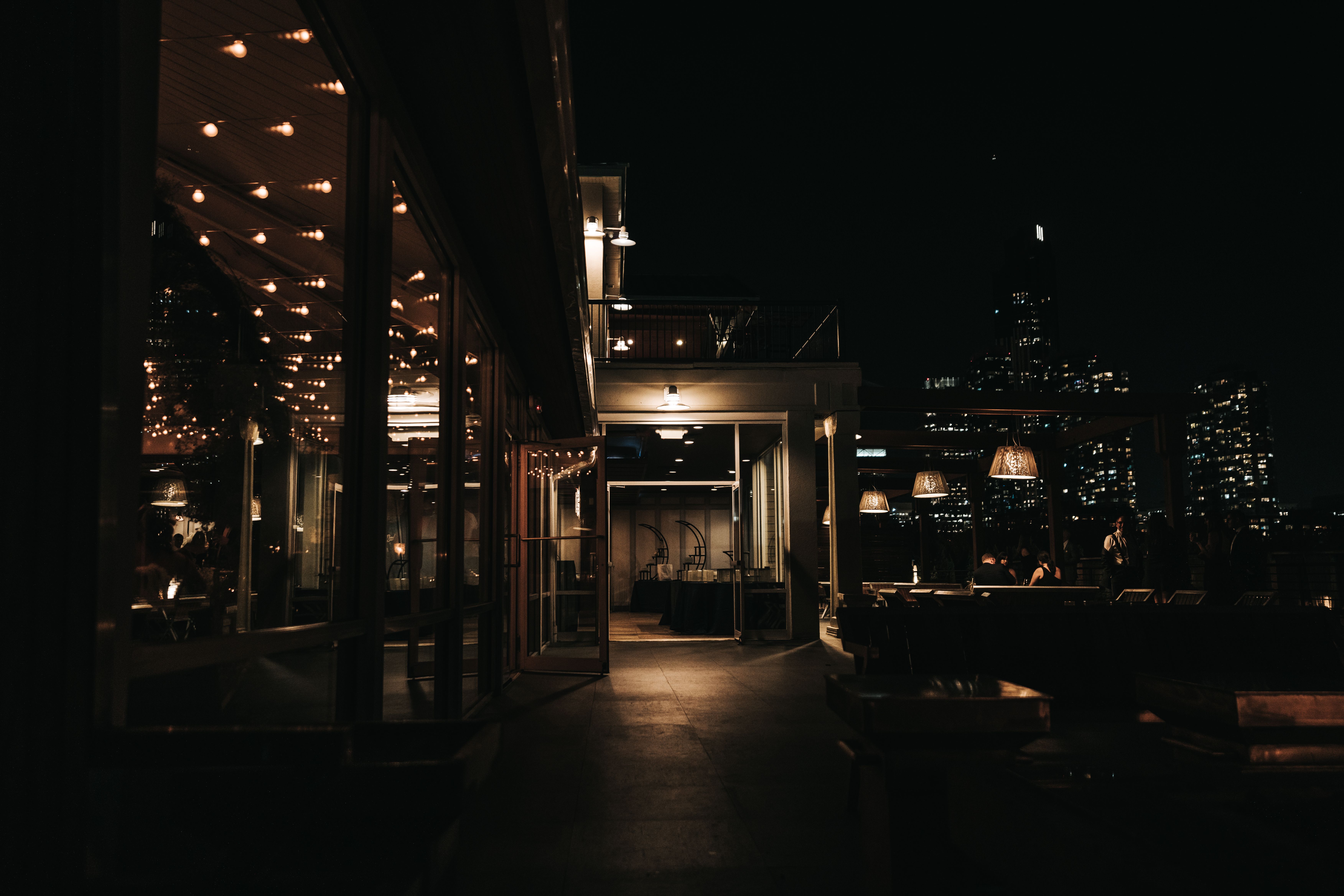 An atmospheric rooftop bar with city views, suggesting an upscale night out in Munich.